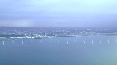 Hava görüntüsü: Endüstriyel liman ve deniz kıyısındaki rüzgar değirmenleriyle Kopenhag havaalanına akşam üzeri yaklaşıyoruz.