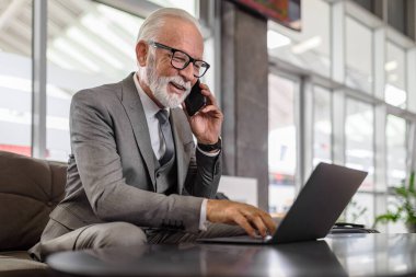 Akıllı telefonla konuşan kendine güvenen bir girişimci. Gülümseyen son sınıf öğrencisi masadaki dizüstü bilgisayarda çalışıyor. Tren istasyonunun bekleme salonunda otururken takım elbise giyiyor..