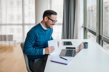 Şirketimizin saygıdeğer sahibi, bilgisayarında bir video görüşmesi yapıyor, masasına dokümanları yığıyor..
