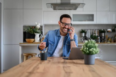 Erkek girişimci cep telefonuyla gülümsüyor ve iletişim kuruyor.