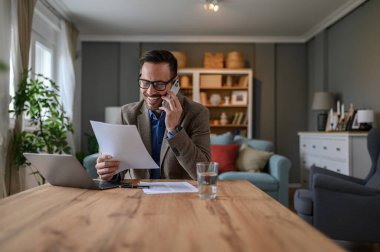 Zarif takım elbiseli bir erkek mali danışman masabaşında iş görüşmeleri hakkında konuşuyor.