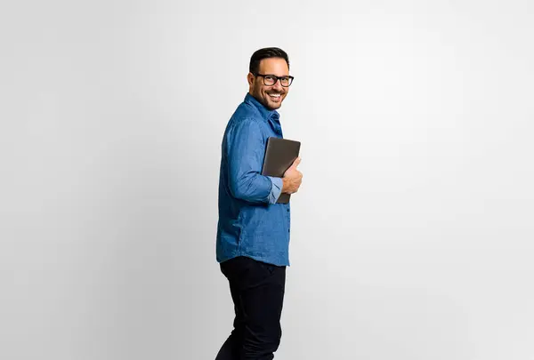 stock image Side view of positive handsome businessman with digital tablet looking at camera on white background