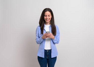 Mutlu kendine güvenen iş kadını sosyal medyayı akıllı telefondan izole edilmiş beyaz arka plana karşı kullanıyor