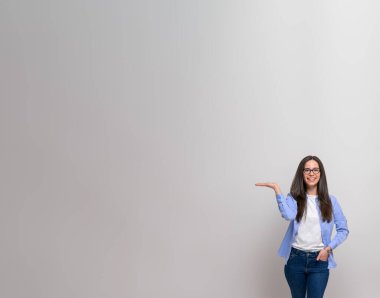 Beyaz arka planda reklam için fotokopi alanında yeni ürünler gösteren iş kadınının portresi