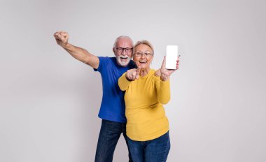 Kendinden geçmiş yaşlı çift çığlık atıyor ve beyaz arka planda akıllı telefonun boş ekranını gösteriyor.