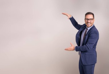 Genç gülümseyen satıcının portresi beyaz arka planda yeni ürünü sunuyor ve reklamını yapıyor.