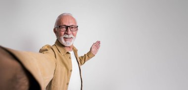 Gülümseyen olgun erkek yönetici izole edilmiş beyaz arkaplana karşı fotokopi alanında yeni ürün sunuyor