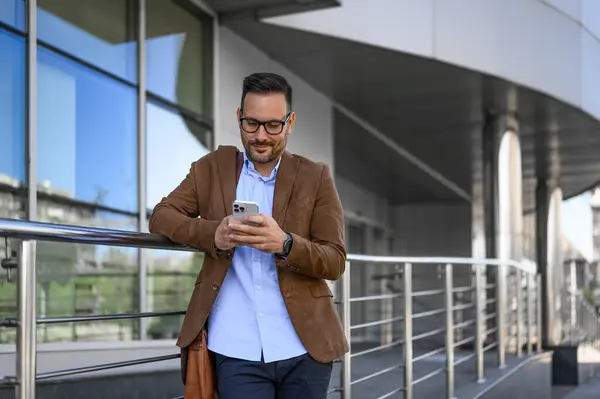 Confident Young Man Checking Business Messages Smartphone Railing Modern Building Ліцензійні Стокові Зображення