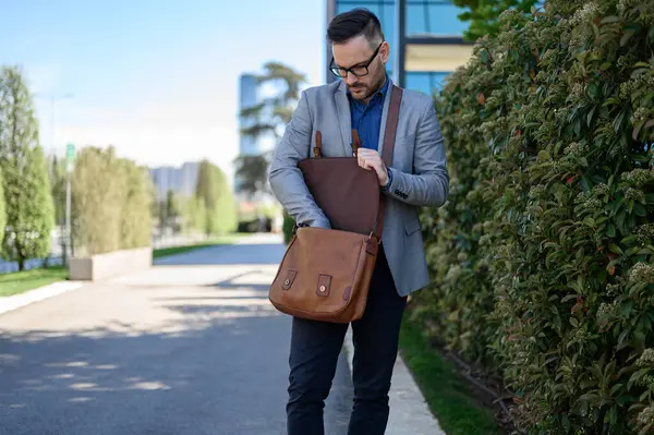 Young Businessman Glasses Searching Brown Laptop Bag While Standing Plants Стокова Картинка