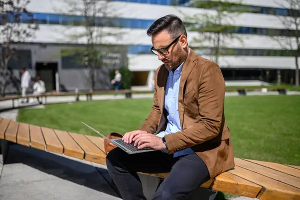 Komoly Vállalkozó Szemüvegben Dolgozik Projekt Laptop Miközben Padon Modern Városban Stock Fotó