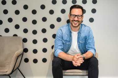 Elleri kelepçeli ve koltukta oturan gözlüklü memnun erkek proje yöneticisi portresi