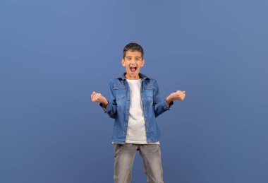 Mest olmuş küçük işadamının portresi mavi arka planda dururken bağırıyor ve yumruklarını sallıyor.