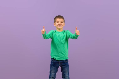 Başarılı genç, sevimli, gülümseyen ve mor arka planda işaret gösteren profesyonel portresi.