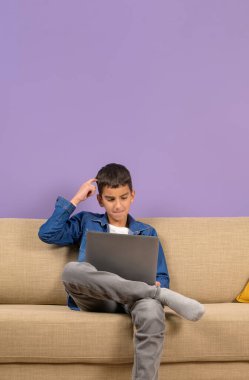 Genç iş adamı, dizüstü bilgisayarla çalışırken mor arka planla ilgili fikirleri düşünüyor.