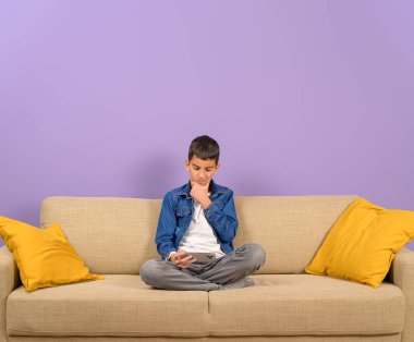 Eli çenesinde düşünceli bir iş adamı. Mor arka planda cep telefonuyla mesajlaşıyor.