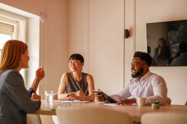 Proje planlama ve toplantı odasında strateji konusunda işbirliği yapan dijital tabletli profesyonel ekip