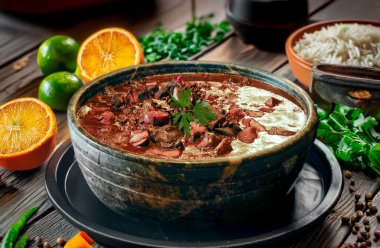 Geleneksel Brezilya yemekleri pilav, farofa, portakal dilimleri, domuz eti ve sosis ile servis edilir.