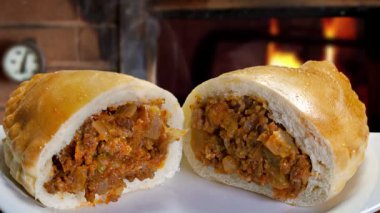 Beyaz arka planda soğan ve domates soslu sığır eti rulosu.