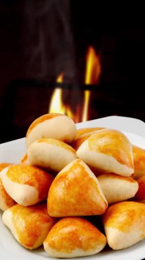 Tahta bir masada peynirli taze pişmiş çörekler..