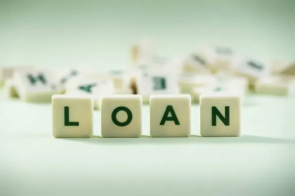 stock image The word LOAN on pastel background, spelt with scrabble tiles