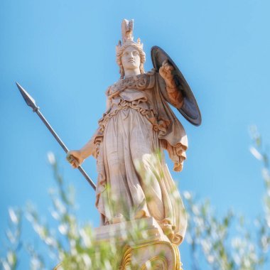 Athena marble statue with helmet, spear and shield, over some olive tree leaves, Athens Greece clipart
