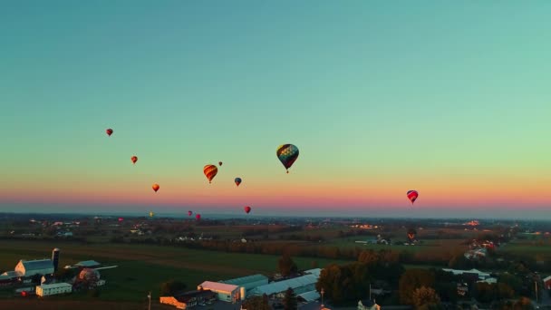 夏の日に 観客が見守る祭りの間に空に浮かぶ複数の熱気球の空中写真 — ストック動画