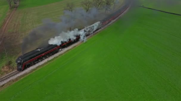 ペンシルベニア州ロンクス 2022年11月12日 晴れた秋の日に煙と蒸気を吹く曲線を周回する蒸気旅客列車の前のドローン — ストック動画