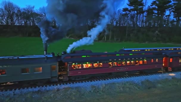 2022年11月26日ペンシルベニア州ロンクス 蒸気機関車のドローンのパラレルナイトビューが別の蒸気機関車がコーチでライトを見て煙をたくさん吹いて起動します — ストック動画