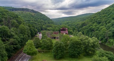 Cass West Virginia 'da terk edilmiş bir kereste fabrikasının drone görüntüsü. Nehir ve demiryolu raylarının yanında.