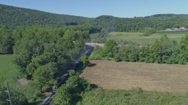 Güneşli bir yaz gününde Pensilvanya 'nın Thru kırsalını gezen Buharlı Yolcu Treni İnsansız Hava Aracı Manzarası