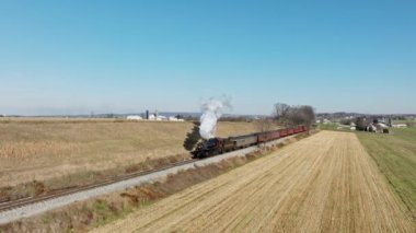 Ronks, Pennsylvania, 12 Aralık 2022 Antik Buharlı Yolcu Treni, Güneşli bir Sonbahar Günü 'nde Thru Çiftliği' nde Seyahat Ederken, Yaklaşan, Tüten Duman 'ın İnsansız Hava Aracı Görüntüsü