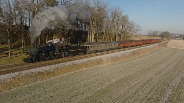 ペンシルベニア州ロンクス 2022年12月30日 アンティーク蒸気旅客列車のスローモーションで 冬の日に農地を旅するドローンビュー — ストック動画