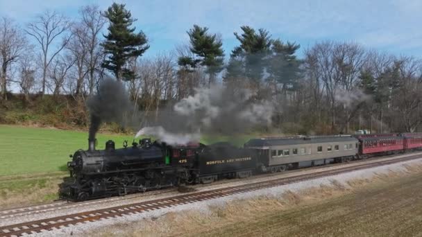 ペンシルベニア州ロンクス 2022年12月4日 無人機のスローモーションが 晴れた秋の日に煙を吹いている小さな駅で 停車中の蒸気旅客列車の視界を引き戻す — ストック動画