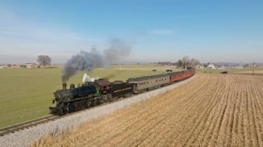 Ronks, Pennsylvania, 30 Aralık 2022 - Güneşli bir kış gününde, Güneşli bir kış gününde, Pensilvanya, Pensilvanya, Pensilvanya, Pensilvanya 'da Bir Hava Önünde ve Yavaş Çekimde, Buharlı Yolcu Treni Yaklaşırken, Dumanı üflerken, Kırsal Yolculuk yaparken,