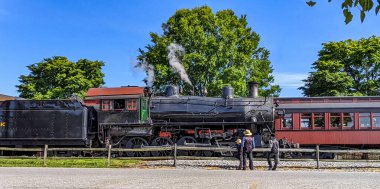 Bir Amish Baba ve Oğulları 'nın Eski Buhar Motoru' na Bakışları Bir Gün Çalışması İçin Hazır Olurken Isınan Buhar Buharı Bakışları.