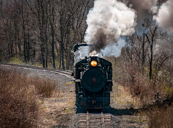 在阳光明媚的冬日 迎面俯瞰并俯瞰正在接近恢复的窄轨距客流列车喷出的烟雾和蒸汽 — 图库照片
