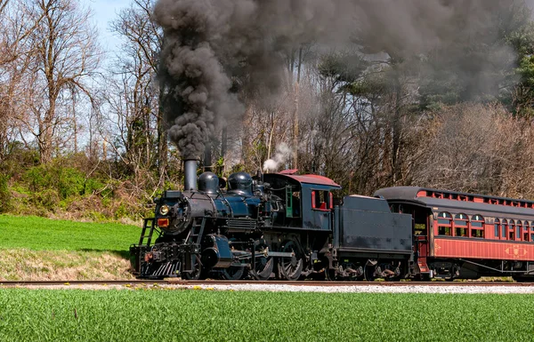 晴れた日にゆっくりと大量の黒い煙と白い蒸気を吹く復元された蒸気旅客列車の天使の景色 — ストック写真