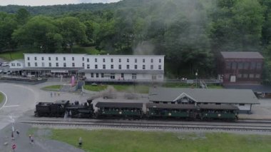 Cass, Batı Virginia, 18 Haziran 2022 Shay Buharlı Motorun İHA görüntüsü Açık Yolcu Koçları Bir Yaz Günü Kara Duman Üfleyen Tren İstasyonundan İniyor