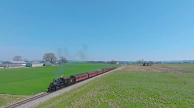 Ronks, Pennsylvania, 3 Nisan 2023 - Buharlı Yolcu Treni 'nin Önünde Uçan Duman Yolcusu, Güneşli bir bahar gününde tek bir Pistte Tarım Alanında Seyahat