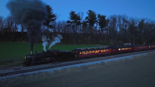 汽笛缓缓前行与平行夜景 一辆停在农场的蒸汽机车在车库里冒出大量烟雾 看到车内的灯光 — 图库视频影像