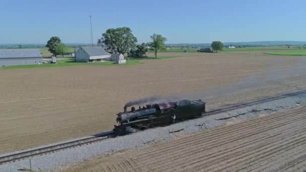 试运行中的蒸汽机车在一条单线上的乡间小路上自己行驶的圆筒视图 在春日的慢动作中 工程师挂在旁边 — 图库视频影像