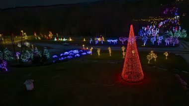 Açık Çayırlar ve Açık Bir Gece Binası 'ndaki Renkli Işıklar, Ağaçlar ve Manzaralarla Büyük Sürücü Noel Gösterimi' nin Drone görüntüsü