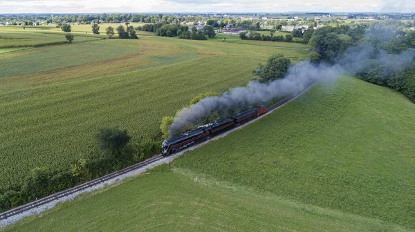 stock image An Aerial View of a Streamlined Steam Locomotive Traveling Around a Curve, Blowing Lots of Smoke on a Sunny Summer Day