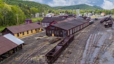 Güneşli bir bahar gününde Kömür Avcıları, Dükkanlar ve Yuvarlak Evler ile Dar bir Tren Garı Avlusu 'nun Havadan Görünümü