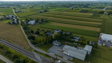 Demiryolu rayları, siloları olan çiftlikler, yamalı araziler ve Alacakaranlık 'ta küçük bir bina kümesi..