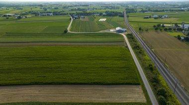 Yüksek Açılı Manzara Uzakta Tarım Alanlarının verimli bir duvar halısını kesen Yol ve demiryolu raylarını gösteriyor.