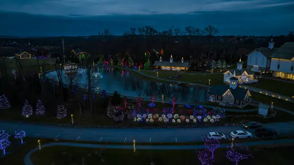 トワイライトは木に囲まれたセレンパークを見下ろし お祝いのライトで装飾された構造 水の反射を鋳造 — ストック写真