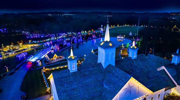 夜のクリスマスライトのカラフルな配列に囲まれたオーナイトビルとポンドの複合体のオーバーヘッドビュー — ストック写真