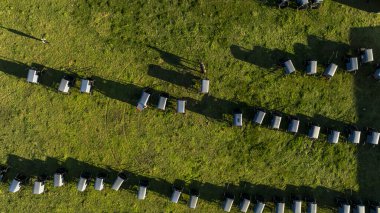 Gökyüzünden, Amiş arabalarının düzenli bir şekilde düzenlenmesi çimenlerin üzerine uzun gölgeler düşürüyor, günlerin sonunda bir topluluk ve gelenek hissi uyandırıyor. Bir Amish Düğünü sırasında