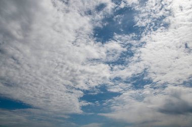 Gökyüzü mavi ve bulutlu. Bulutlar beyaz ve kabarık